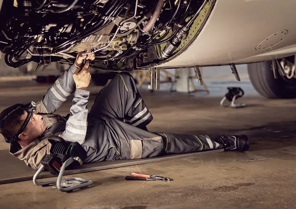 Mechanic working under a plane engine